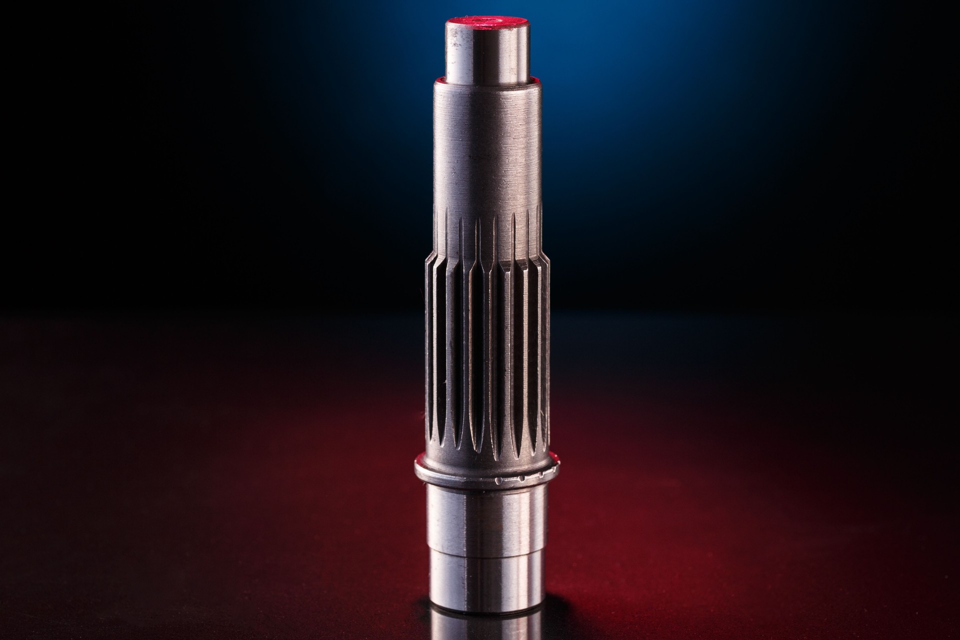 A close-up studio shot of a metallic drive shaft